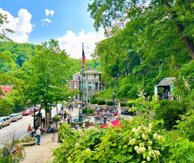 A view from street level of downtown Eureka Springs surrounded in lush green foliage.